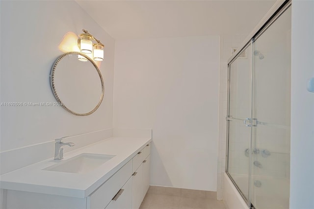 bathroom with tile patterned flooring, vanity, and enclosed tub / shower combo