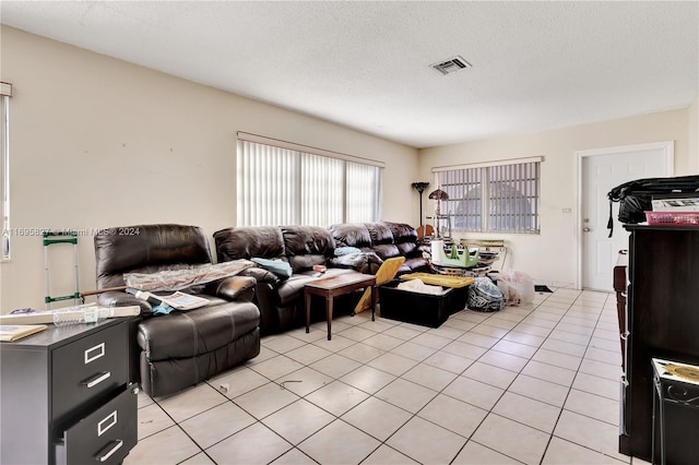 tiled living room featuring a textured ceiling