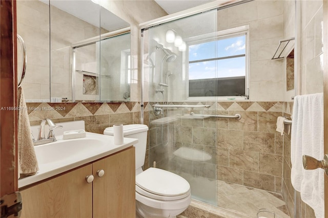 bathroom featuring walk in shower, vanity, tile walls, and toilet