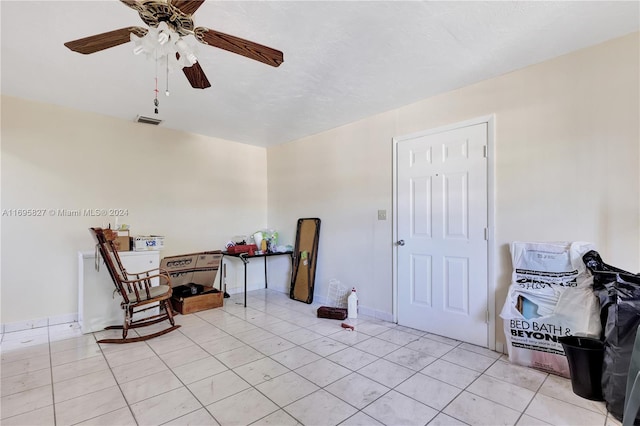 living area featuring light tile patterned floors and ceiling fan