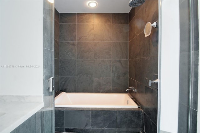 bathroom with tiled shower / bath and tile walls