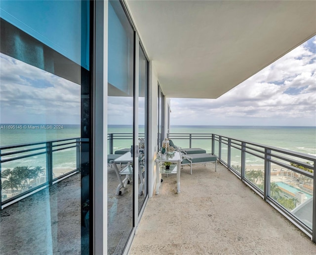 balcony with a water view and a beach view