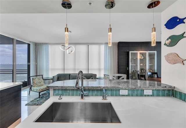 kitchen with decorative light fixtures, floor to ceiling windows, and sink