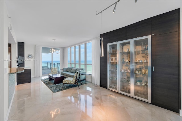 living room with a notable chandelier, floor to ceiling windows, and a water view