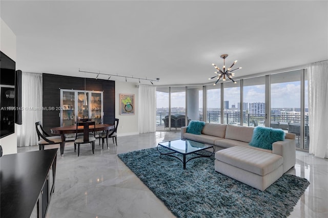 living room featuring a chandelier, track lighting, and expansive windows