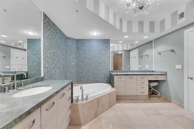 bathroom featuring tile patterned flooring, a relaxing tiled tub, vanity, and a chandelier