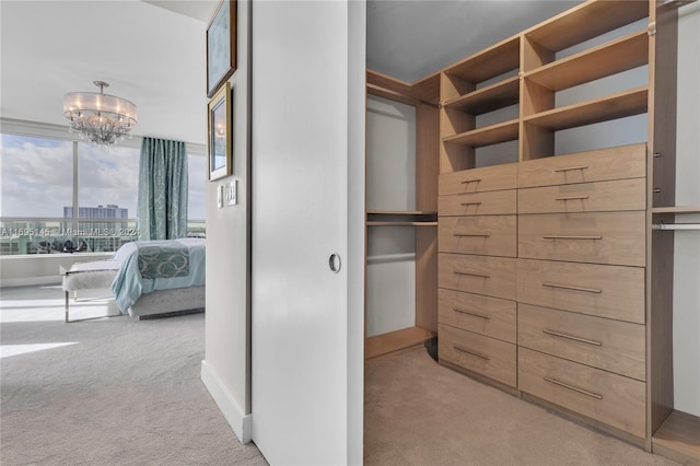 spacious closet with light carpet and a notable chandelier