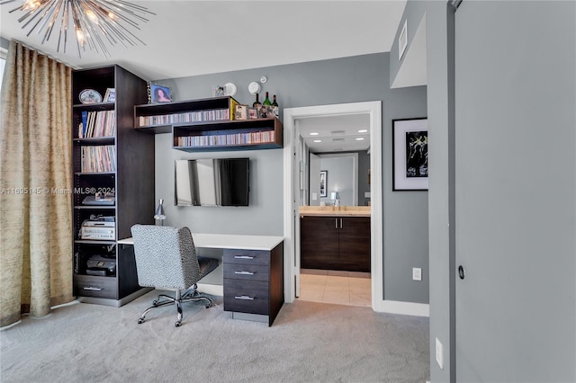 home office featuring a notable chandelier, sink, and light carpet