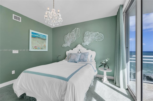 bedroom with carpet flooring, a water view, and a chandelier