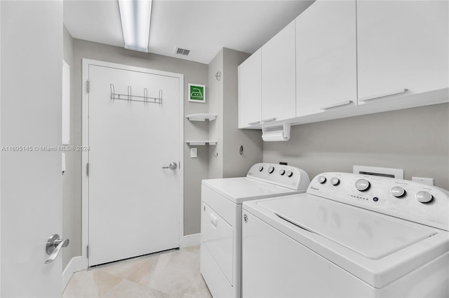 laundry room with washer and dryer and cabinets