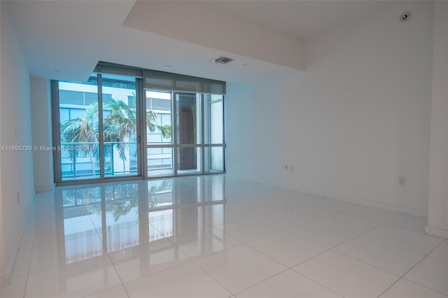 unfurnished room featuring floor to ceiling windows and light tile patterned floors