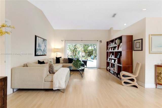 living room with light hardwood / wood-style flooring and vaulted ceiling