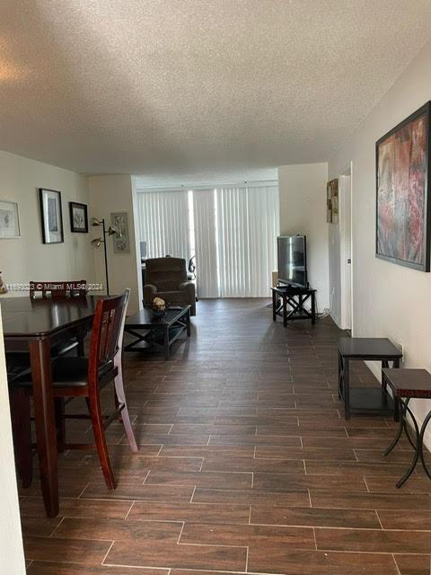 living room with dark wood-type flooring and a textured ceiling