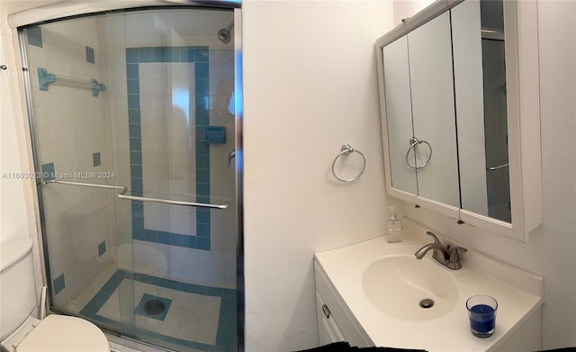 bathroom featuring vanity, toilet, and a shower with door