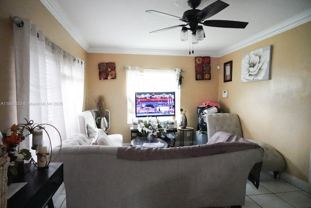 living area with light tile patterned floors, baseboards, a ceiling fan, and crown molding