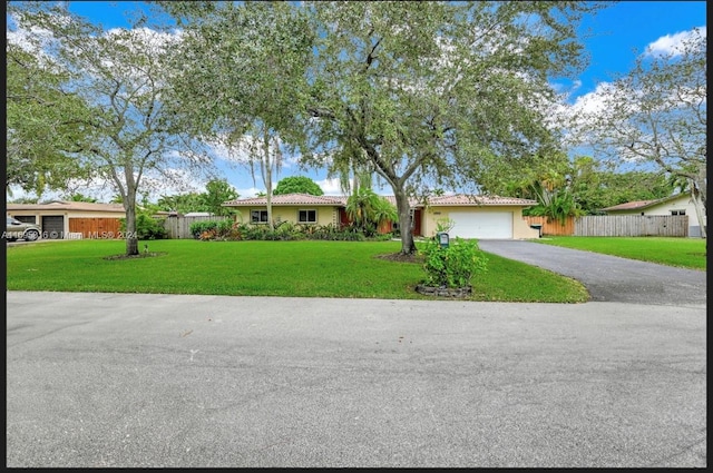 ranch-style home with a front yard and a garage