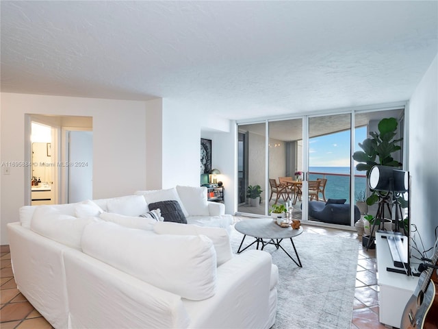 tiled living room with a wall of windows and a textured ceiling