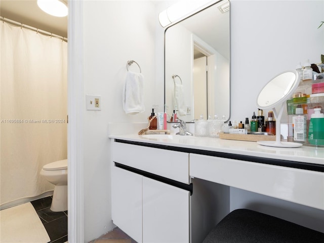 bathroom with tile patterned flooring, vanity, and toilet