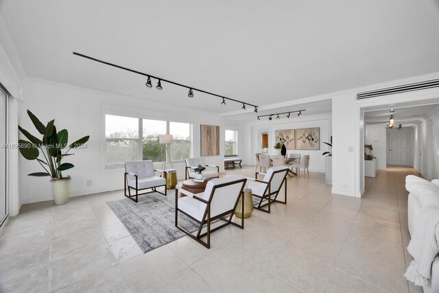 tiled living room with track lighting and ornamental molding