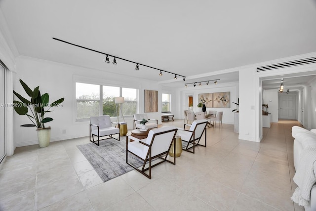 living room with baseboards, ornamental molding, and light tile patterned flooring