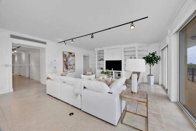 tiled living room featuring built in shelves, track lighting, and crown molding