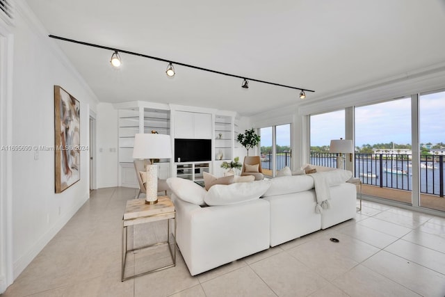 tiled living room featuring built in features, ornamental molding, and track lighting