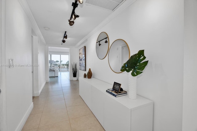 corridor featuring crown molding and light tile patterned floors