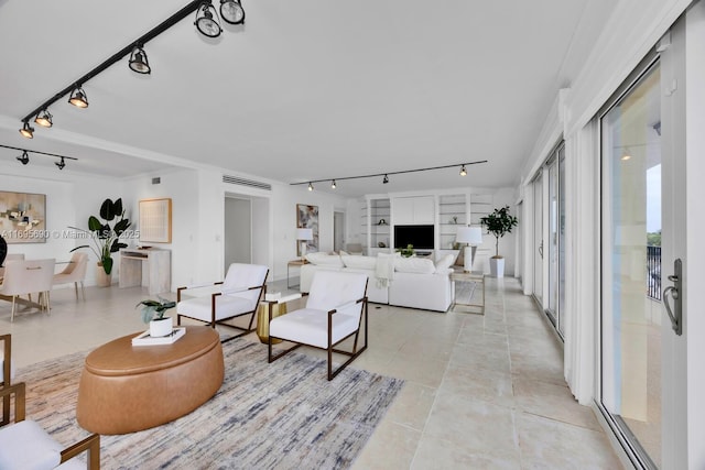 living area featuring built in shelves, light tile patterned flooring, and track lighting