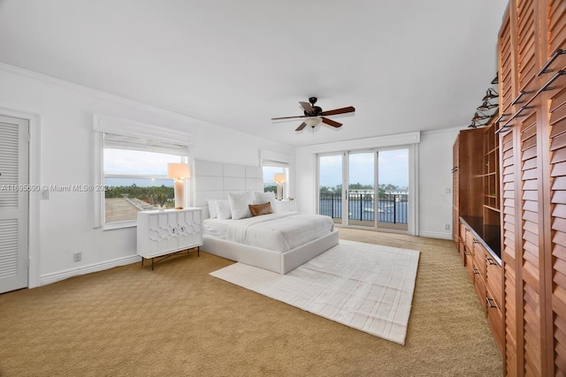 unfurnished bedroom with carpet, access to exterior, a water view, and multiple windows