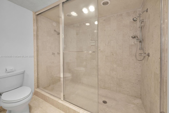 bathroom with a shower stall and toilet