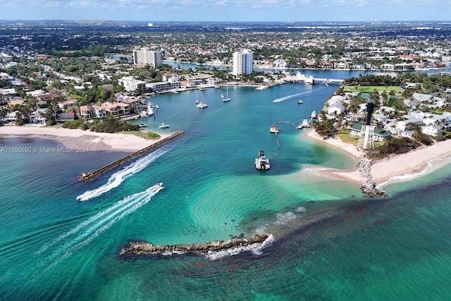 birds eye view of property with a water view and a beach view