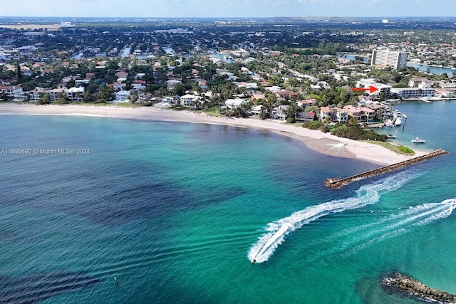 birds eye view of property featuring a water view and a beach view