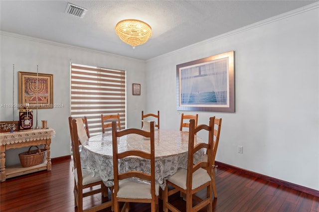 dining room featuring dark hardwood / wood-style flooring, ornamental molding, and a textured ceiling