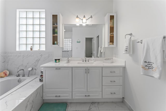 bathroom with vanity and tiled tub