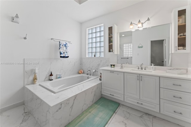 bathroom featuring tiled bath and vanity