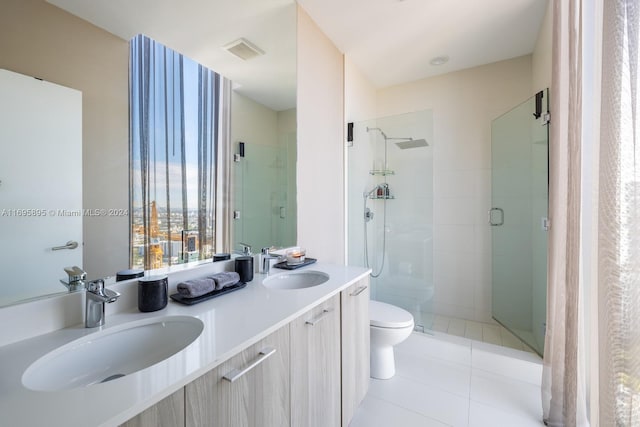 bathroom with toilet, vanity, tile patterned floors, and a shower with door