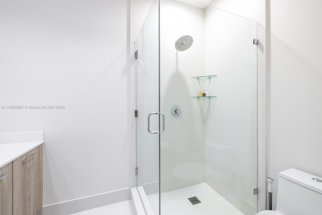 bathroom with tile patterned floors, vanity, toilet, and an enclosed shower