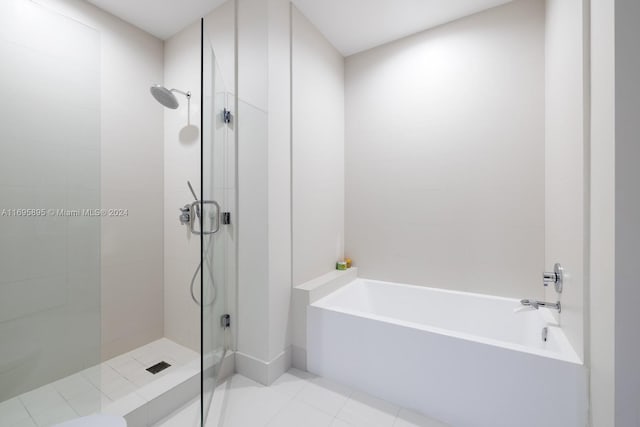 bathroom featuring tile patterned flooring and shower with separate bathtub