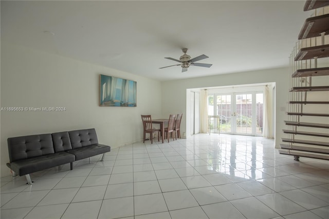 tiled living room featuring french doors and ceiling fan