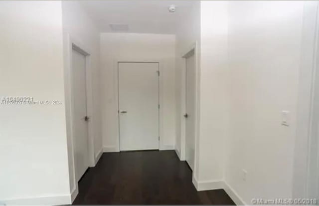 corridor with dark hardwood / wood-style flooring