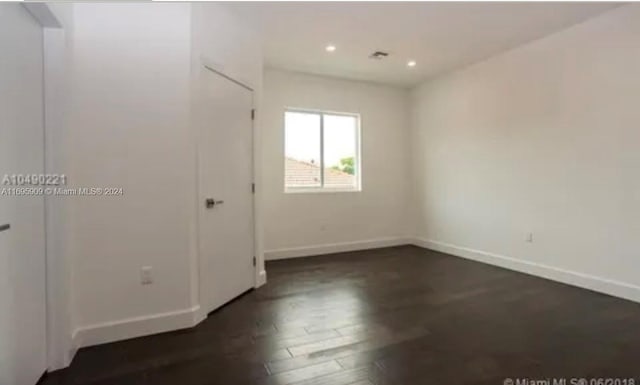 empty room with dark wood-type flooring