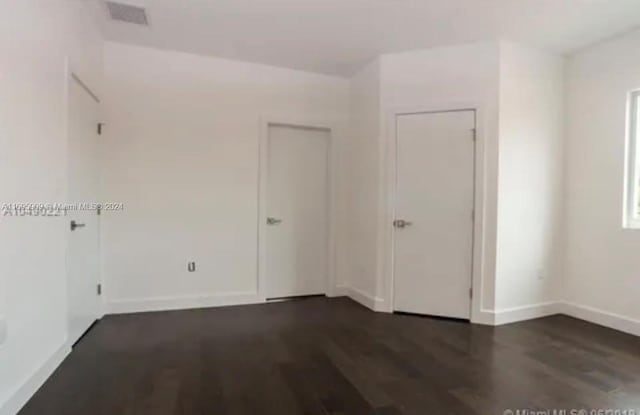 empty room with dark wood-type flooring