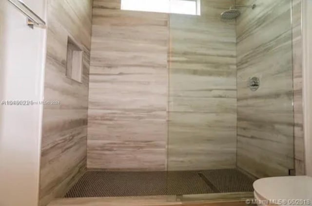 bathroom with toilet and a tile shower