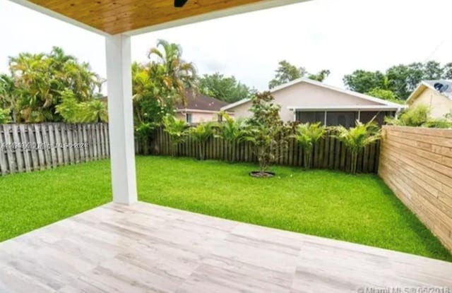 view of yard featuring ceiling fan and a sunroom