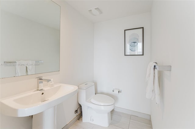 bathroom featuring tile patterned flooring, toilet, and sink