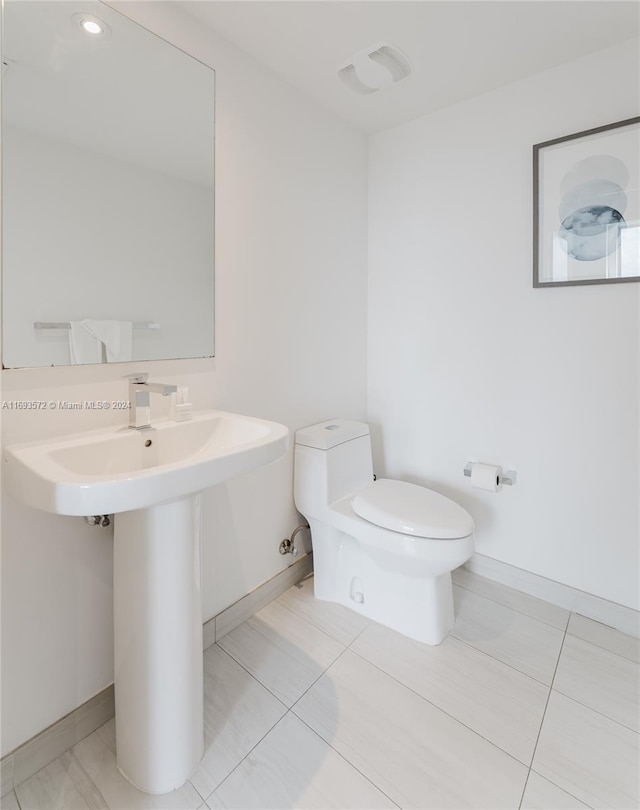 bathroom featuring tile patterned flooring, toilet, and sink