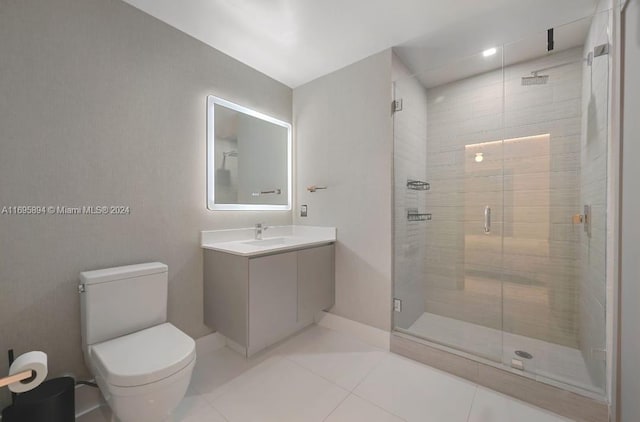 bathroom featuring tile patterned floors, vanity, a shower with shower door, and toilet