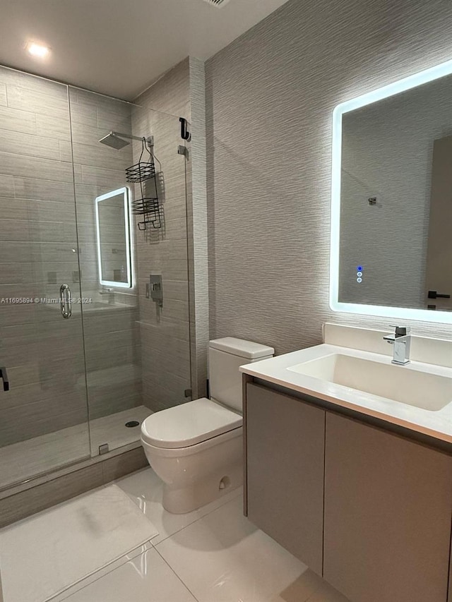 bathroom with tile patterned floors, vanity, toilet, and walk in shower