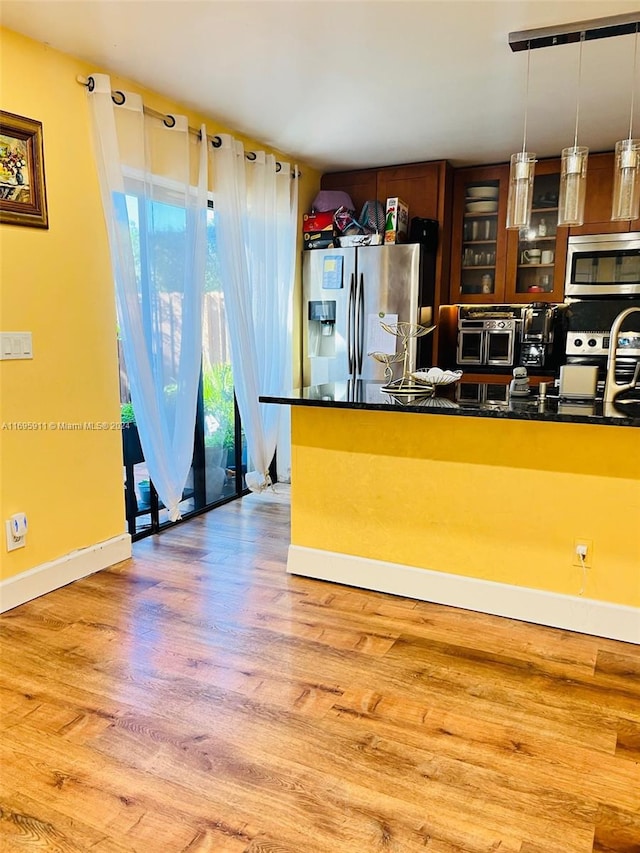 kitchen with pendant lighting, light hardwood / wood-style floors, and appliances with stainless steel finishes