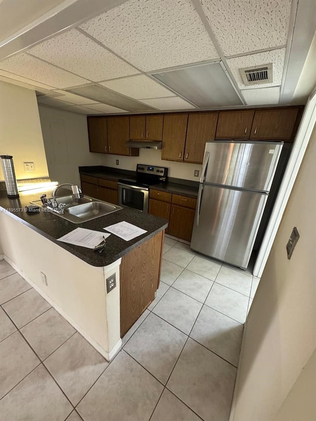 kitchen with light tile patterned floors, a paneled ceiling, stainless steel appliances, and sink